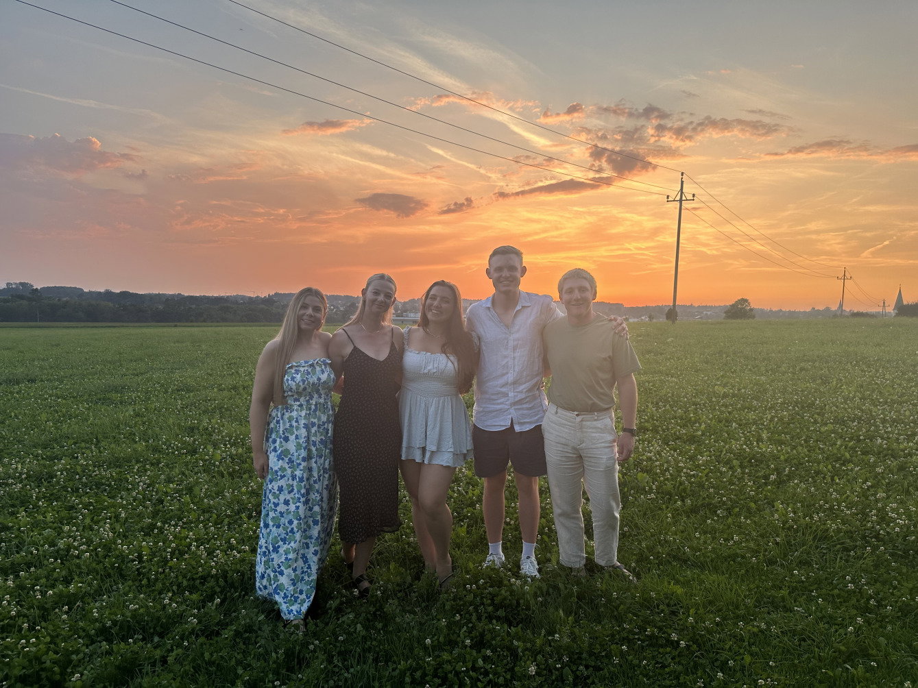 Group of travellers smiling together in the Austrian Alps during sunset