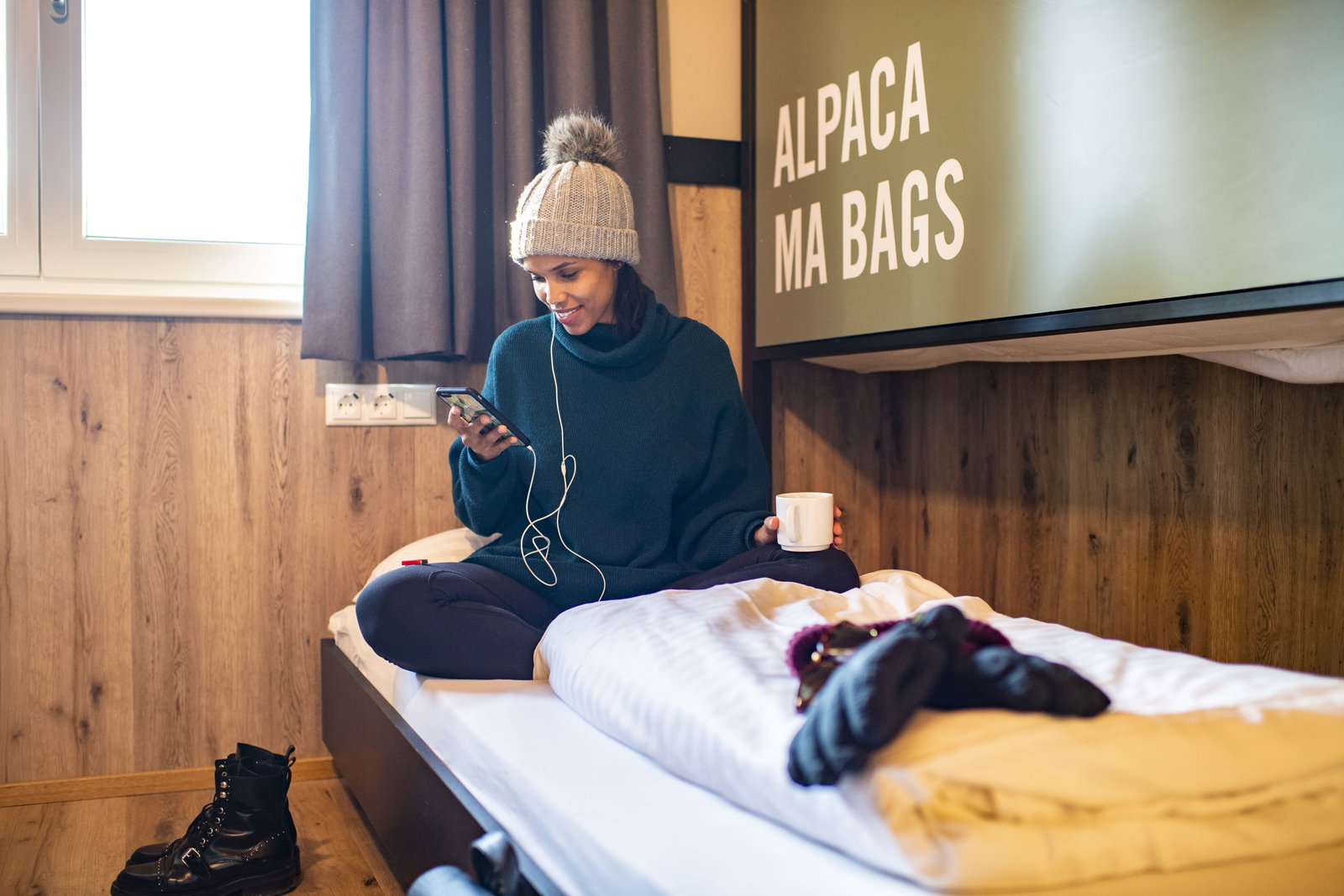 Woman sat on bed in Austria Ski chalet