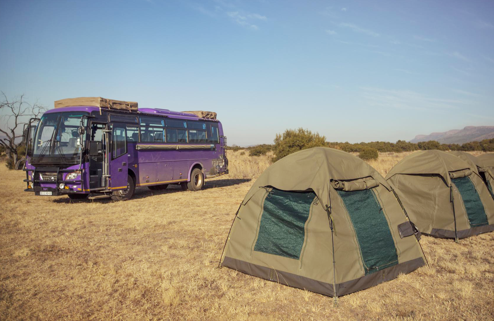 Tents next to lando vehicle in Africa national park