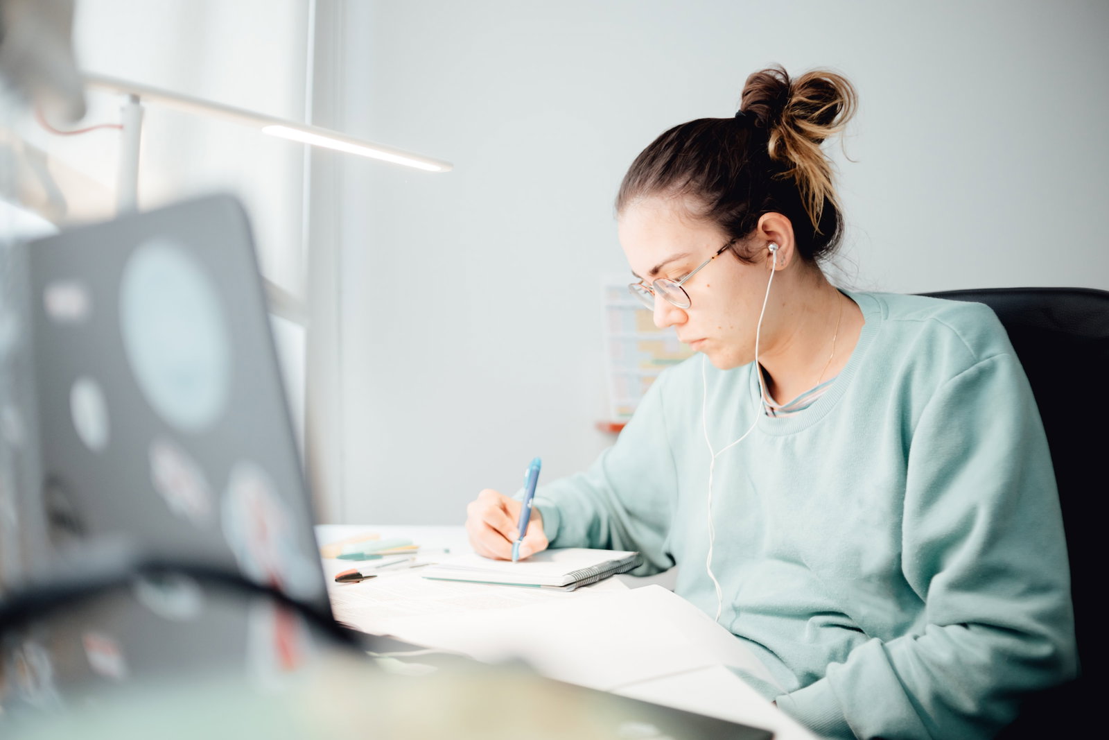 Person studying at a desk with earphones in