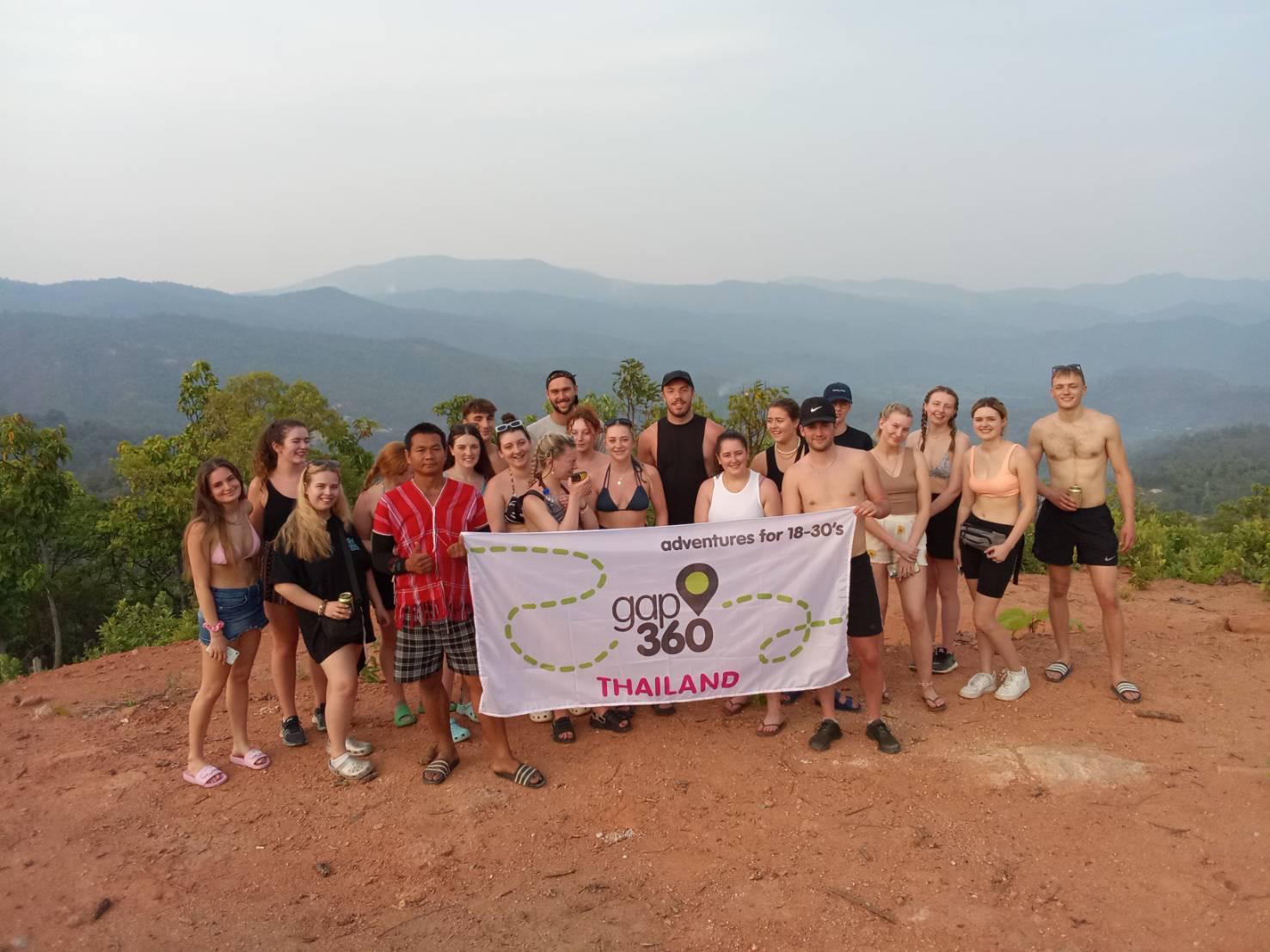 Group in rural Chiang Mai with Adventure360 flag 
