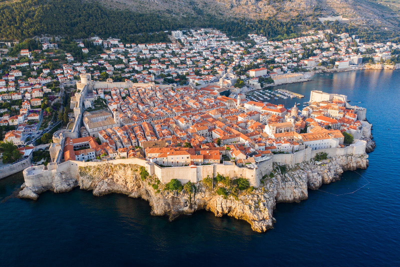Aerial shot of Dubrovnik's Medieval city walls and rugged cliffs with Croatian style architecture inside