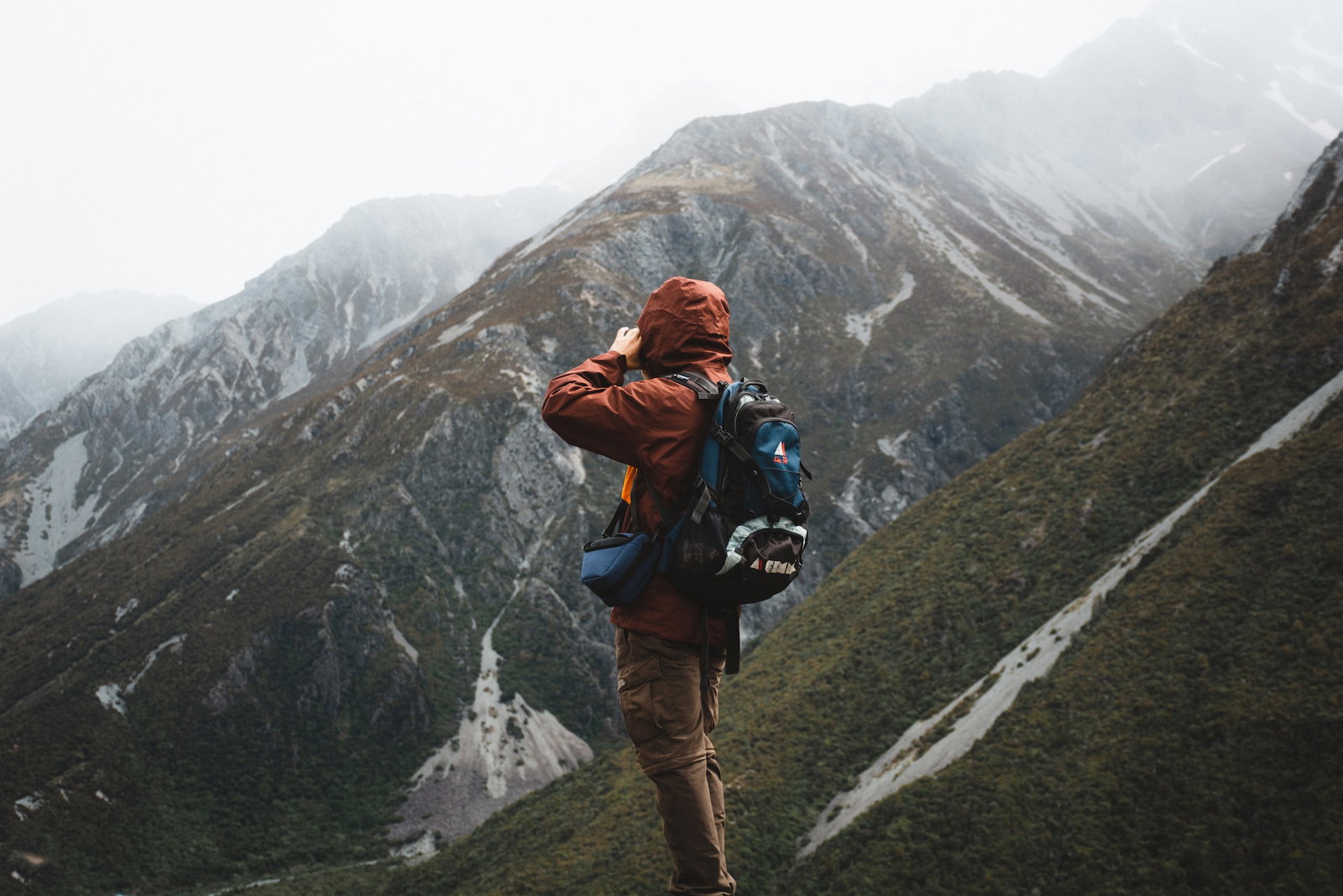 A traveller standing on a mountain taking a photo