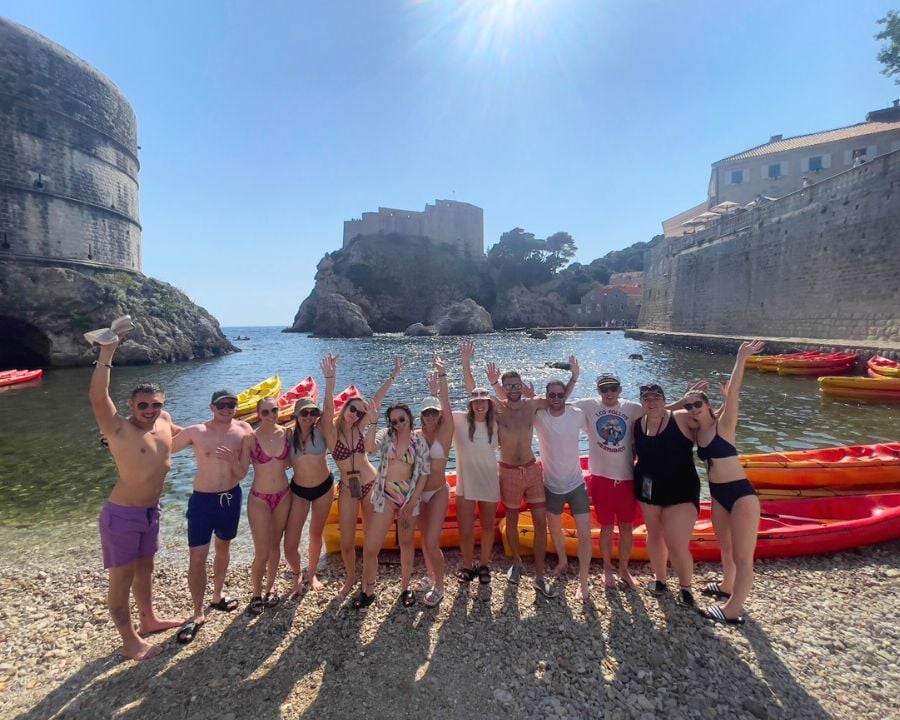 Group of travellers on beach with kayaks in Dubrovnik