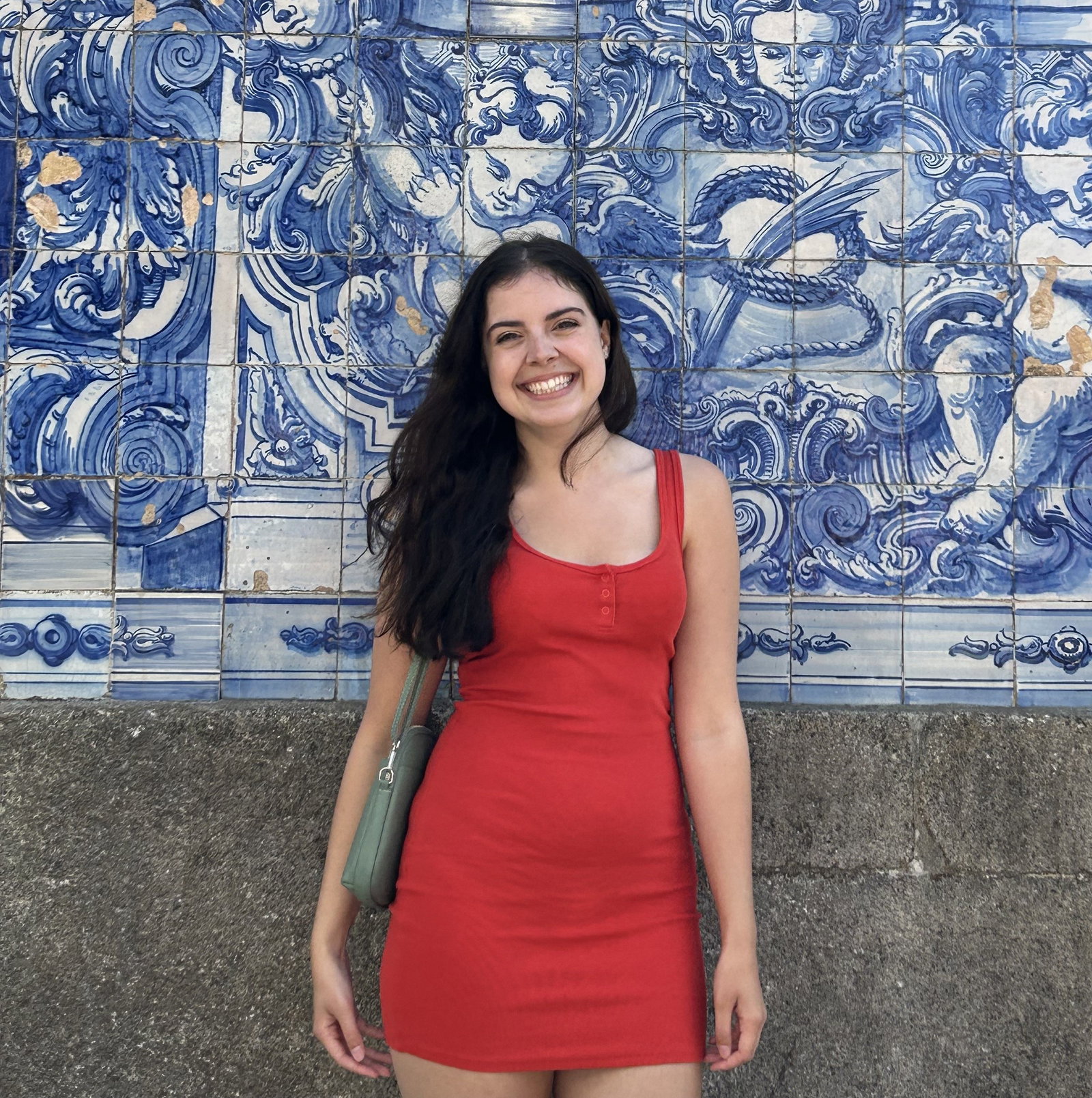 Woman in red dress in front of blue tiled building, Porto, Portugal