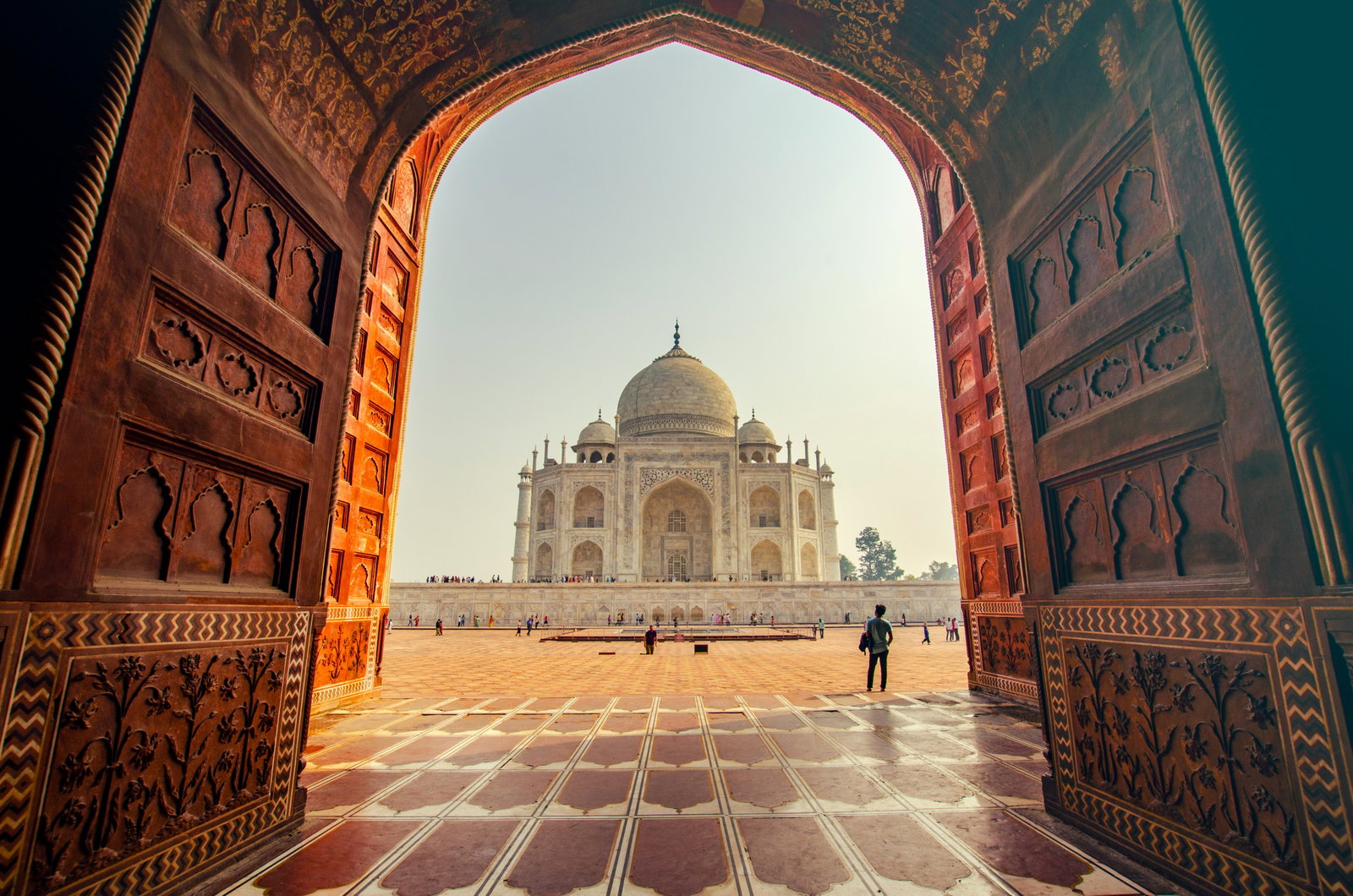 Sunny Taj Mahal through an old large doorway