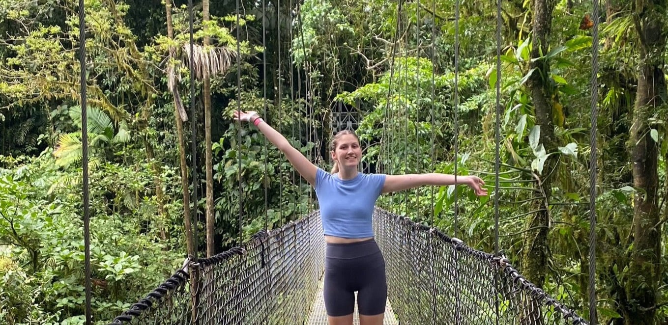 Traveller posing on hanging bridge in La Fortuna rainforest in Costa Rica