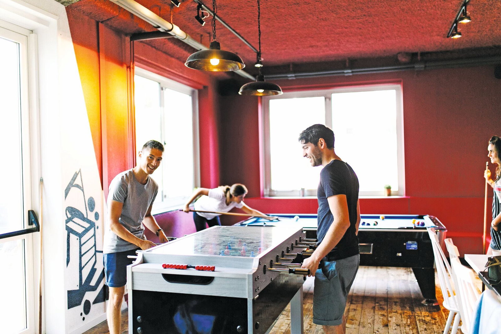 Backpackers playing pool in hostel in europe