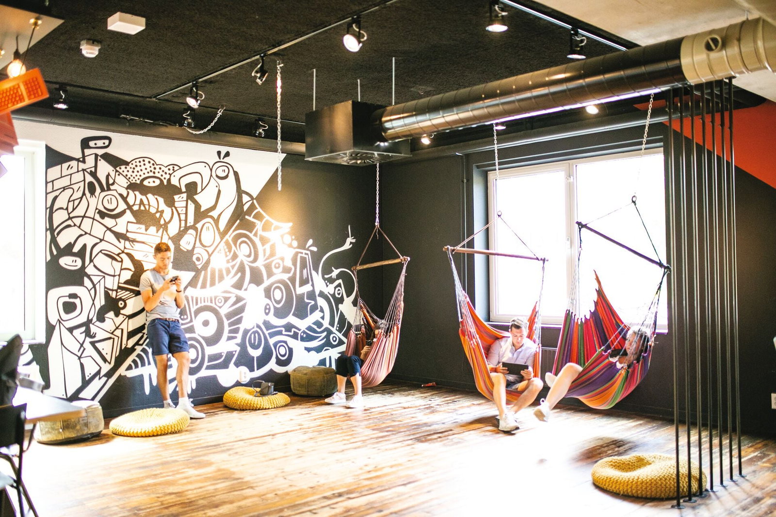 Travellers relaxing in black and white decorated common area in hostel