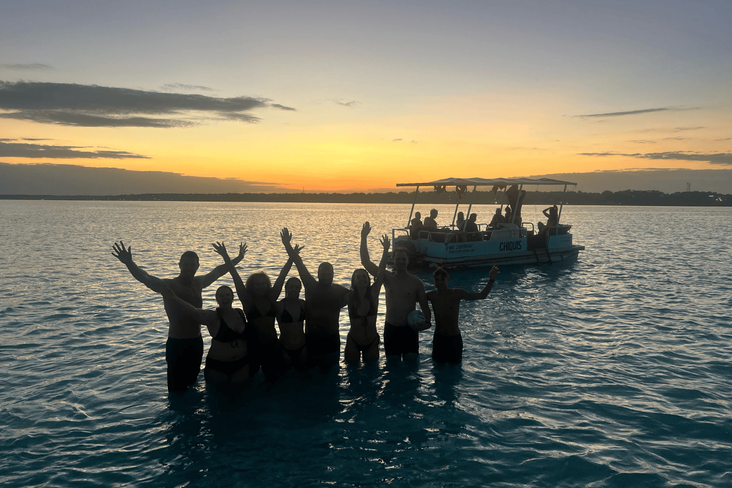 Group travellers in ocean in mexico at sunset