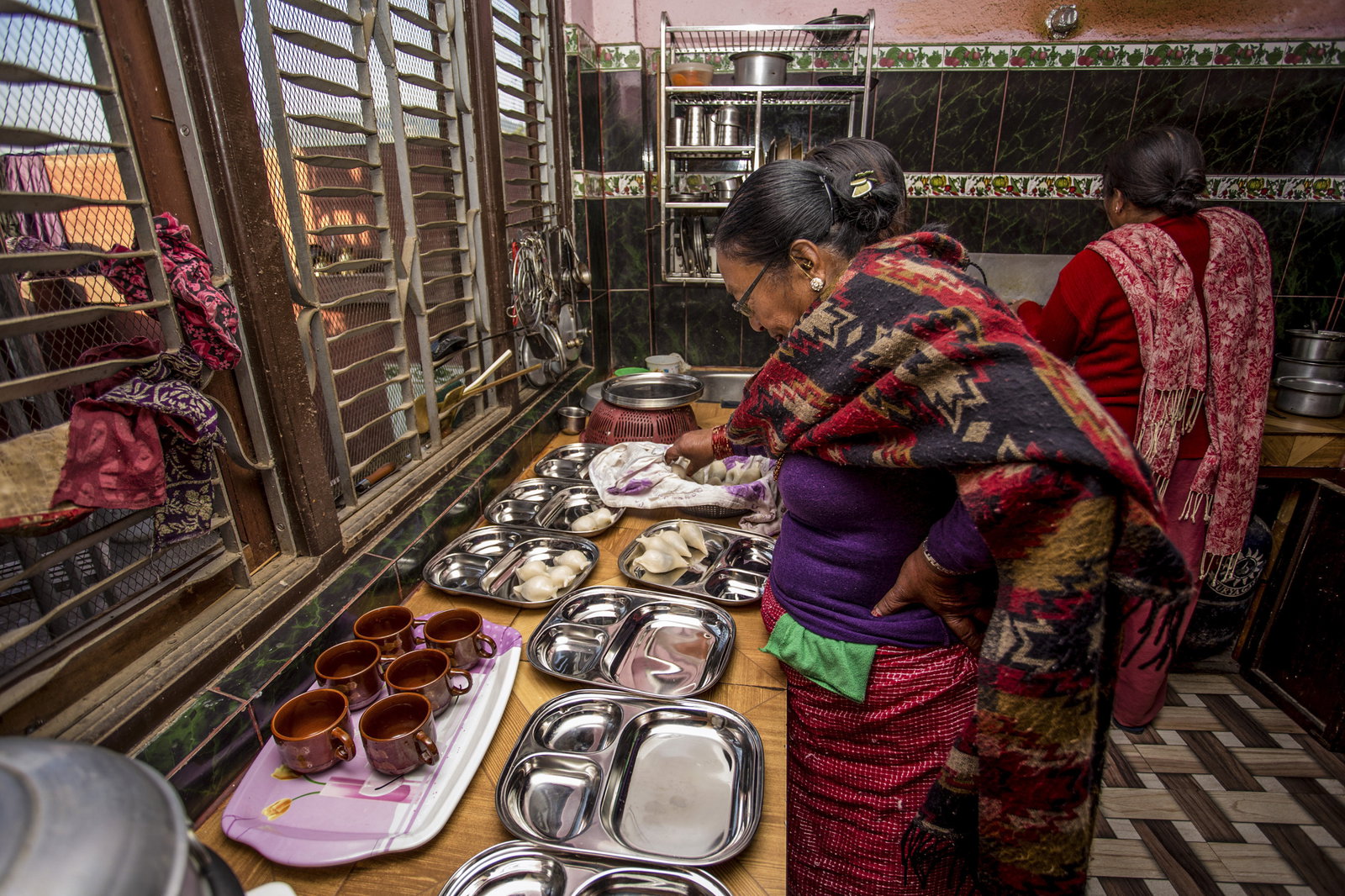 Two ladies preparing food in a kitchen
