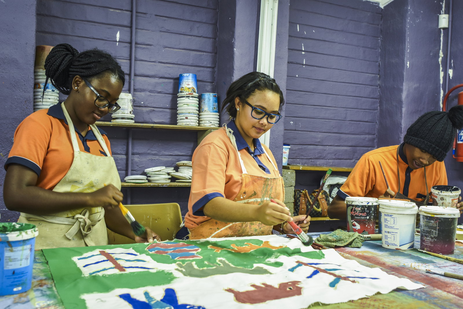 Three people painting in an art studio 