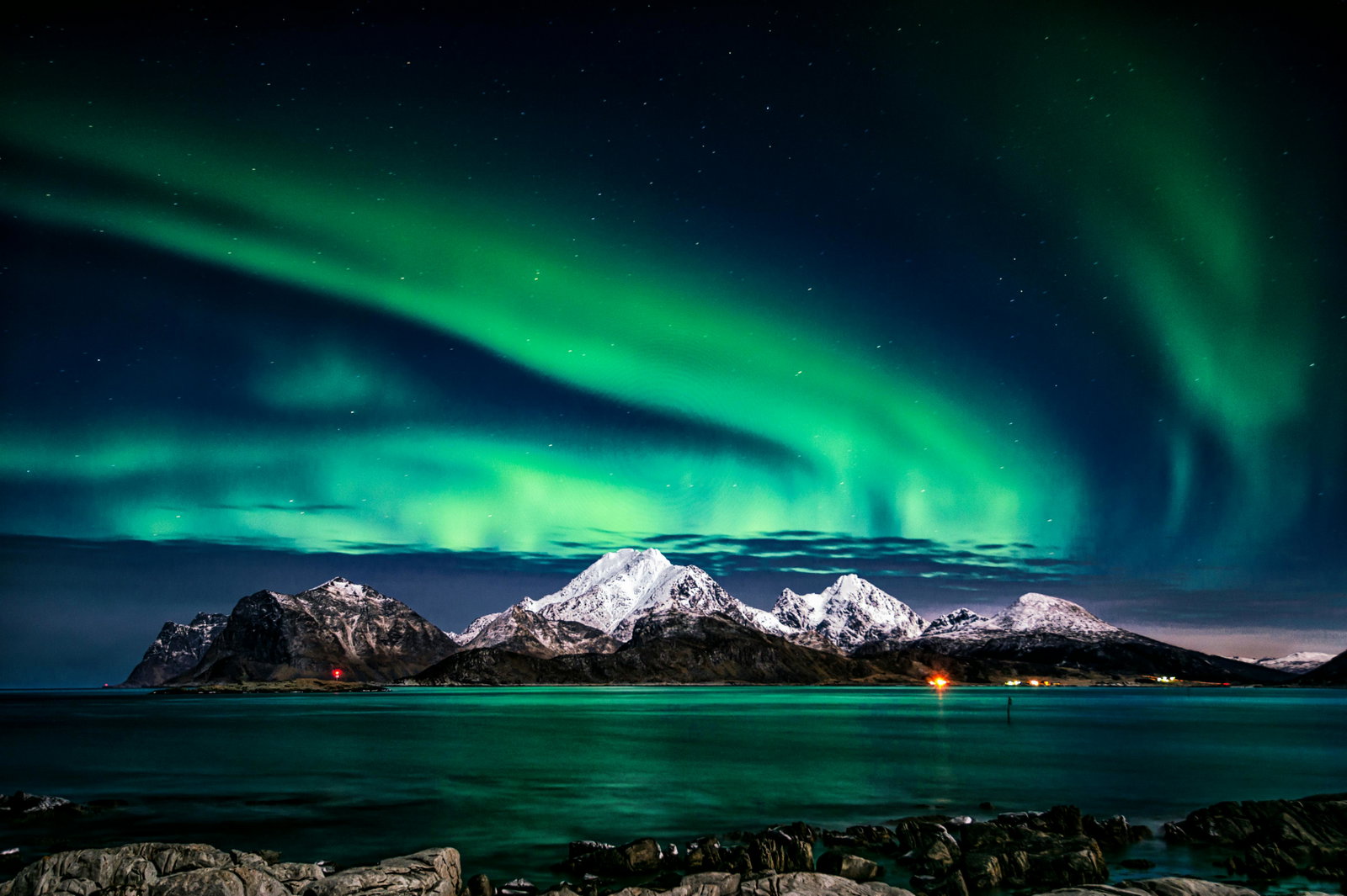 Northern lights in Norway with mountains and Artic sea