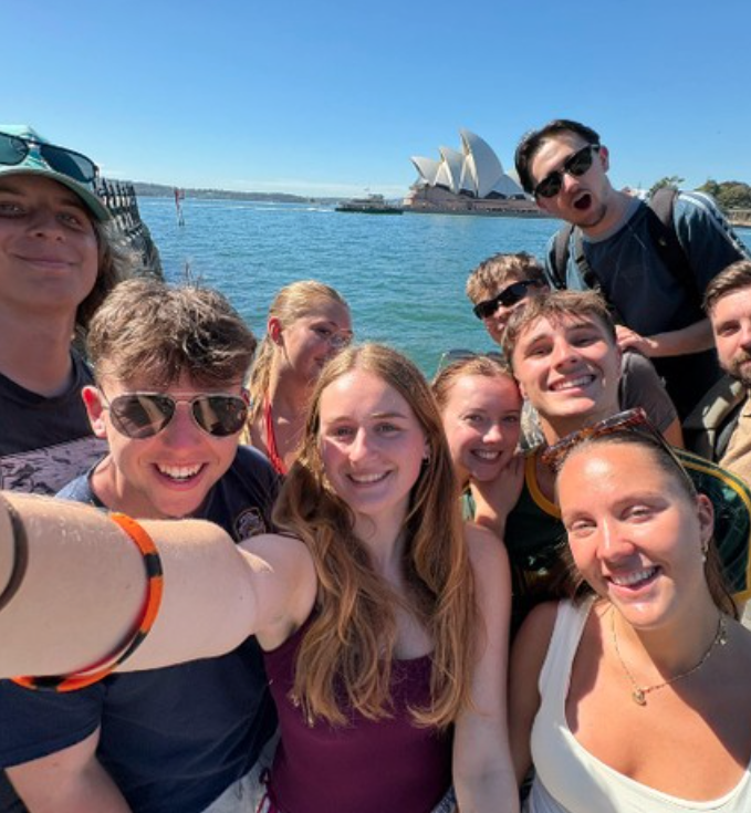 Group of travellers on a group trip in Australia taking a selfie in front of the Sydney Opera House