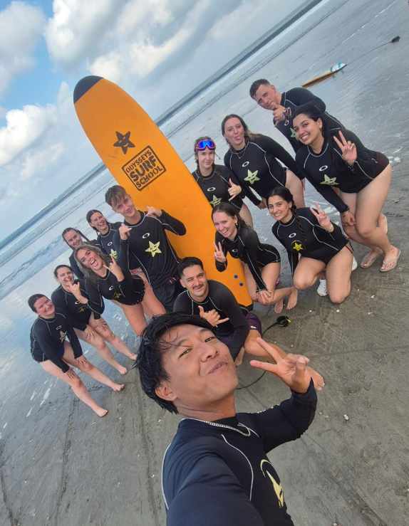 Travellers and their group leader taking a selfie after surf lesson in Canggu on Bali group trip