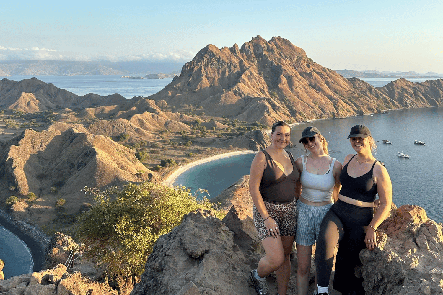 Three people posing together on a rocky viewpoint  at Padar Island Komodo National Park Indonesia