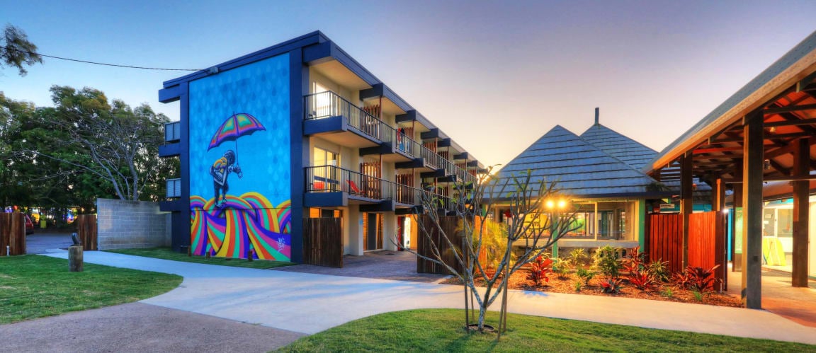View of the colourful exterior of hostel accomodation at dusk