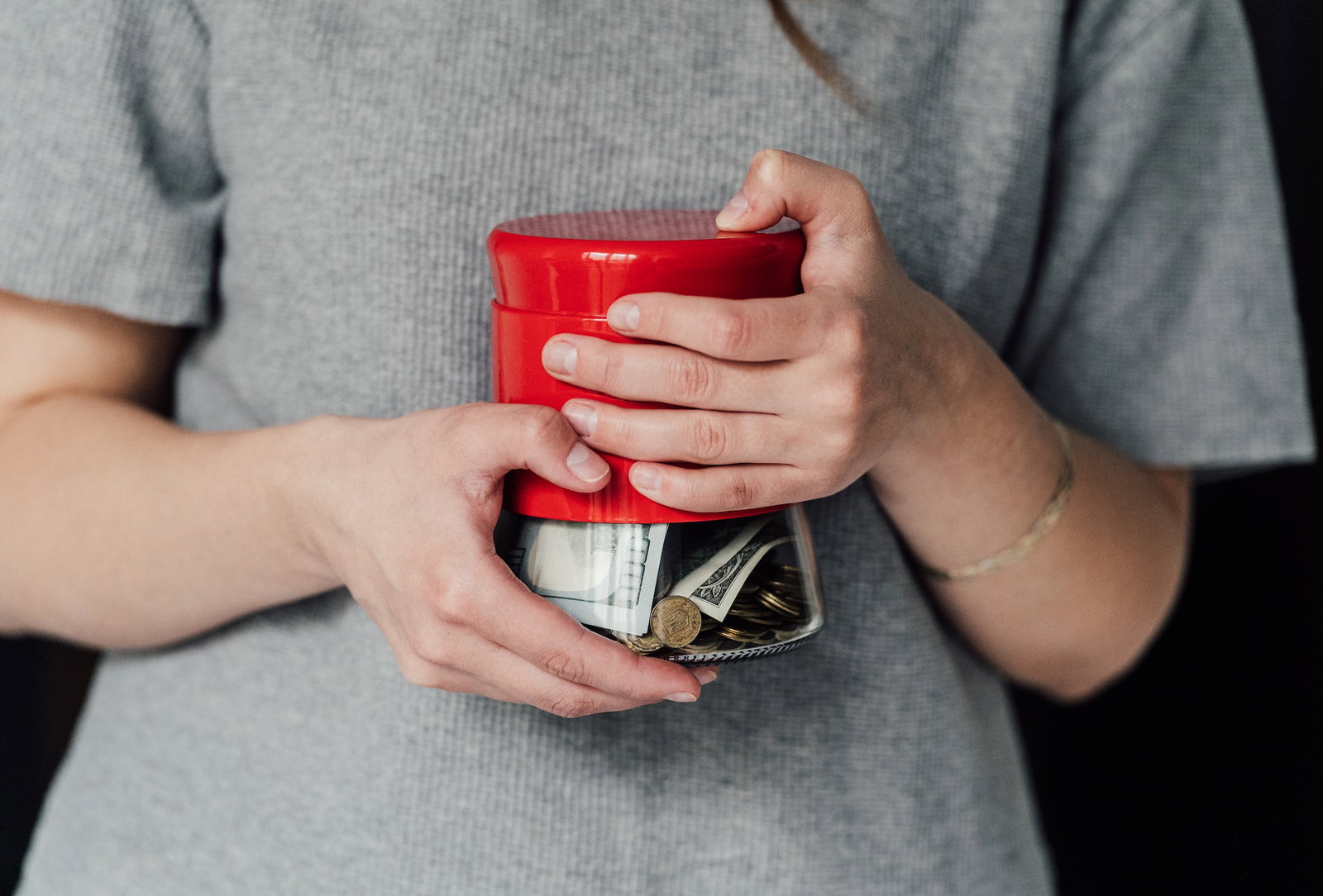 person holding a jar of money