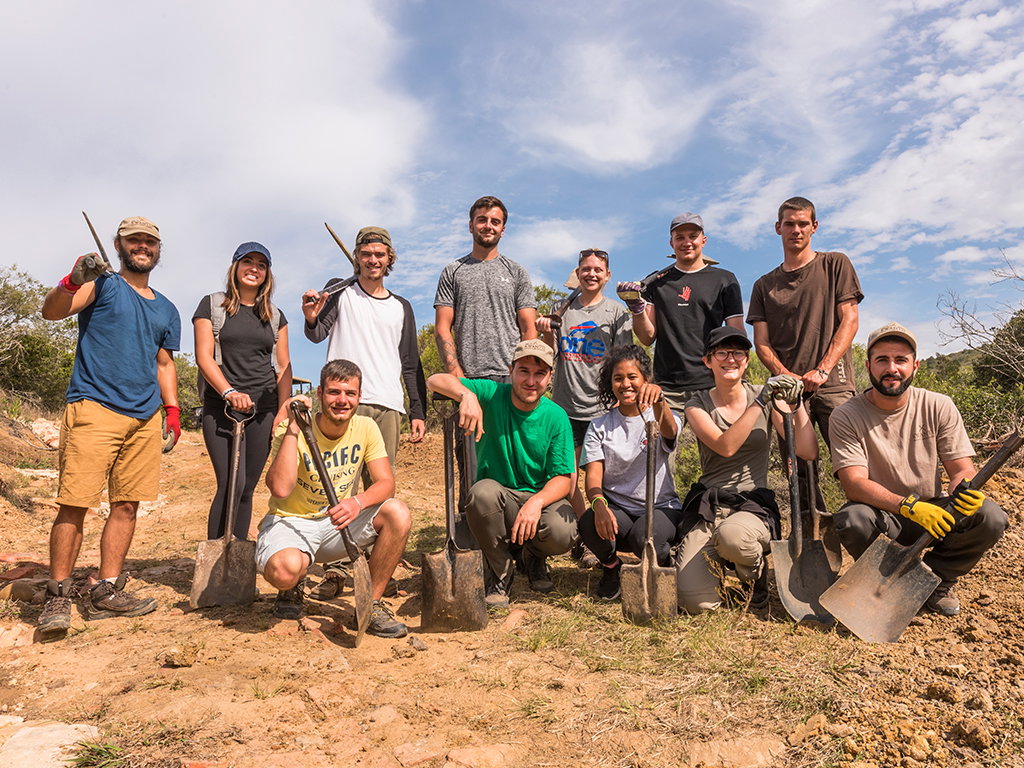A group of travellers holiding shovels and picks